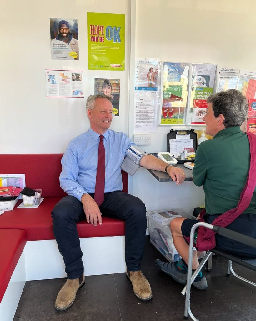 A nurse performing a Health Screening on a man in the Health Hut