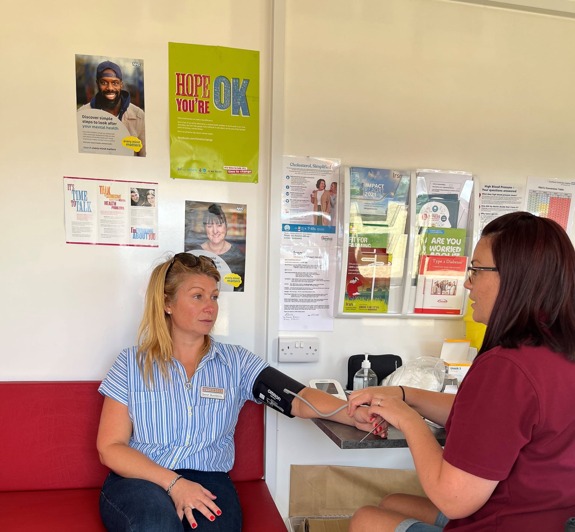 A nurse performing a Health Screening on a lady in the Health Hut