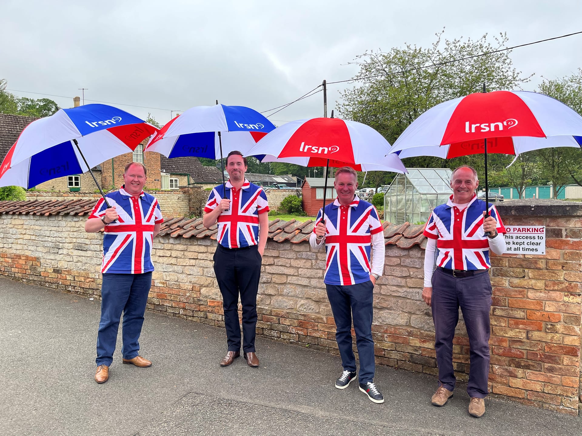 Four men dressed in UK flags carrying LRSN umbrellas