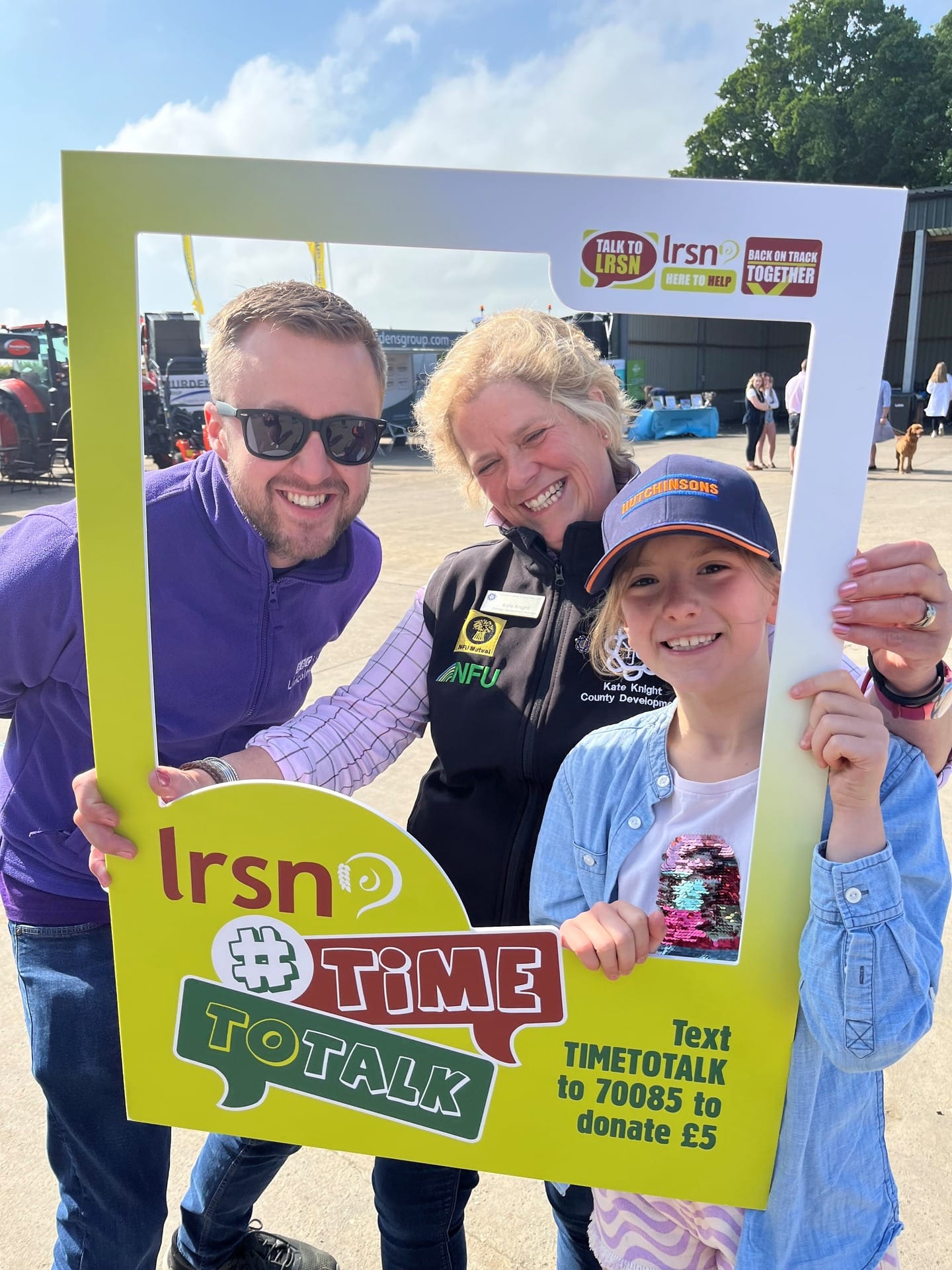 Three people posing for a photo in the LRSN photo frame
