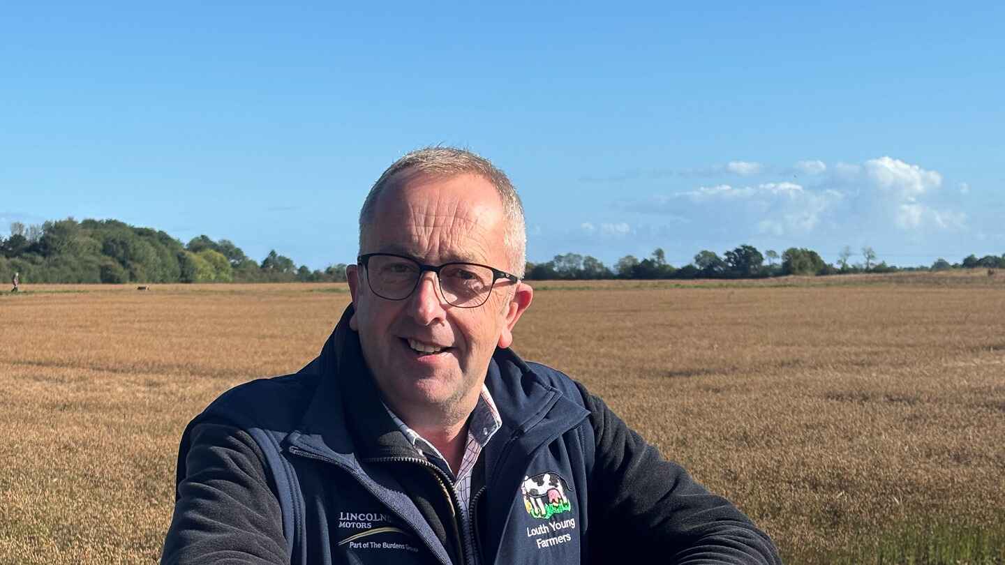 Ian Watson leaning on a fence gate wearing a Louth Young Farmers body warmer
